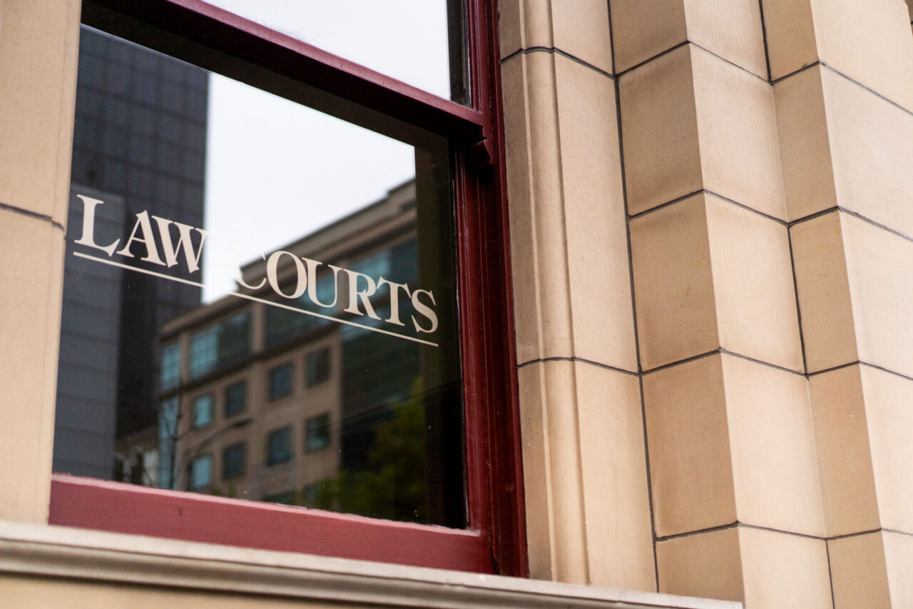 Close up of Law Courts lettering on a window of a heritage sandstone building in Melbourne CBD