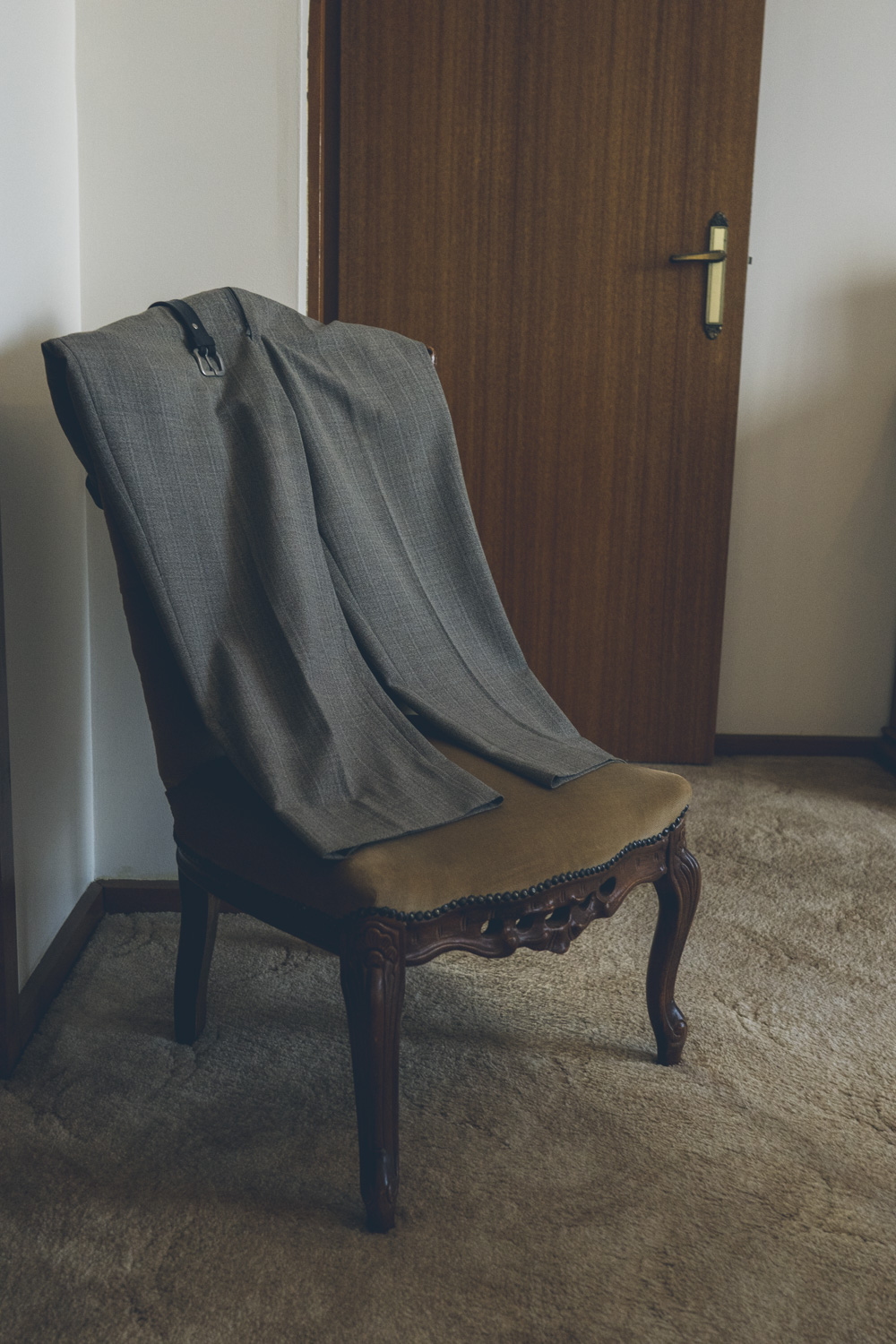 A pair of trousers draped over a chair in a deceased estate, left exactly as they were before the owner passed