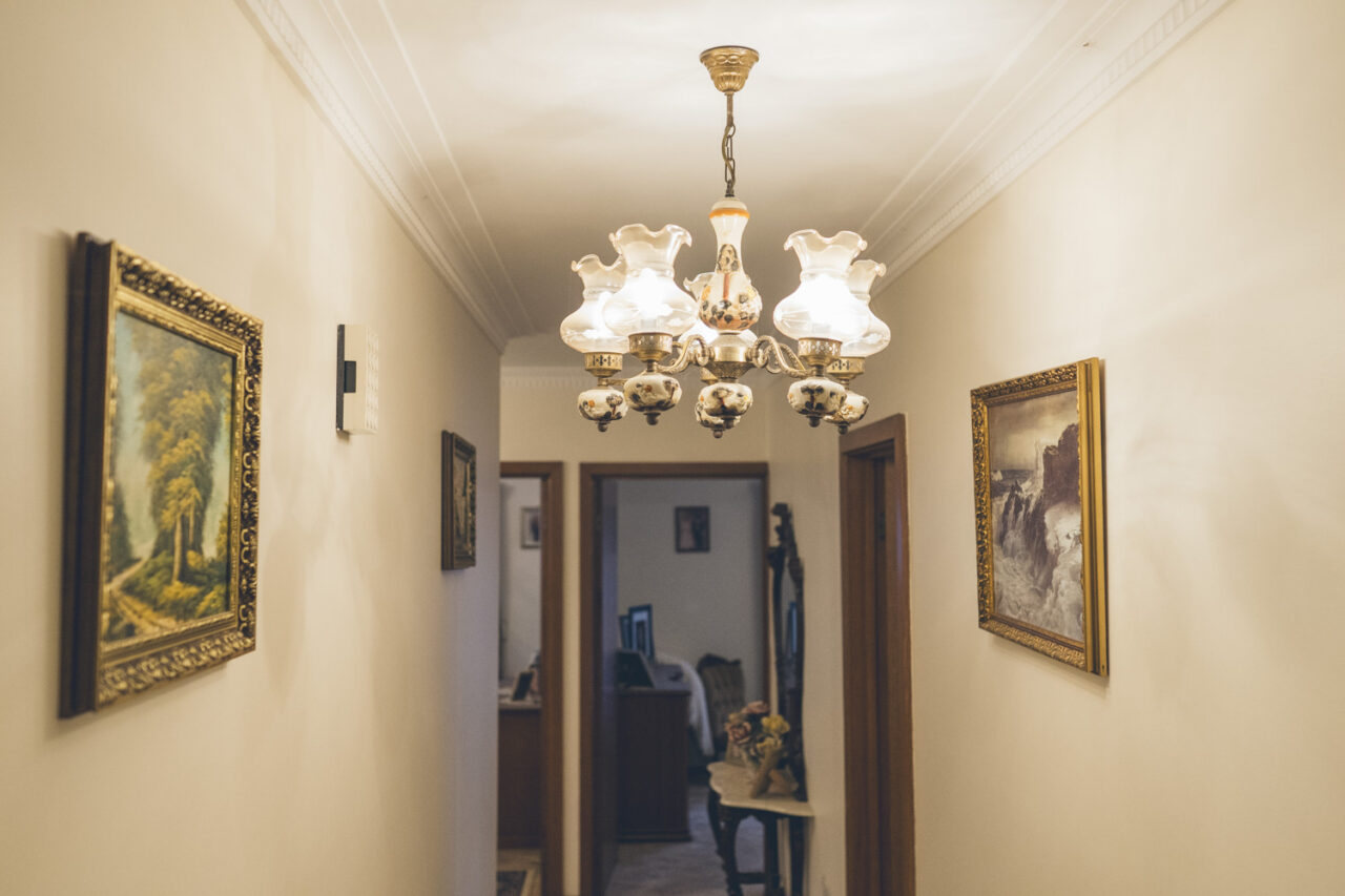 Hallway of a Melbourne family home with ornate chandelier and framed oil paintings, documented before sale by LJM Photography