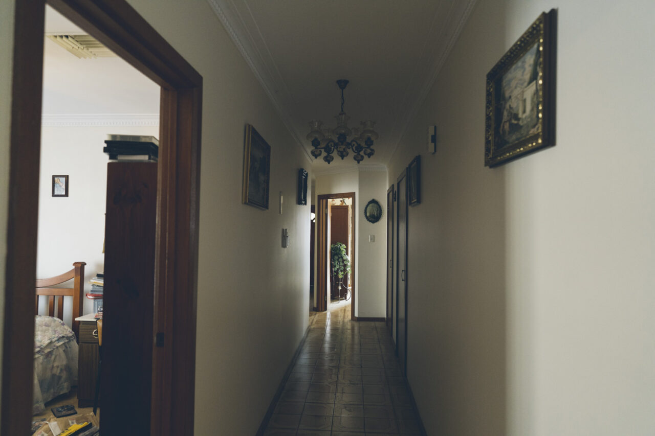 Long hallway of a family home with framed paintings on the walls, documented during a deceased estate session in Melbourne