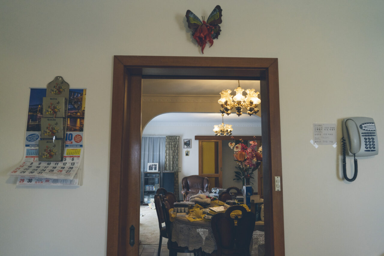 itchen wall with a hanging calendar, wall mounted telephone and view through to the dining room, deceased estate photography Melbourne