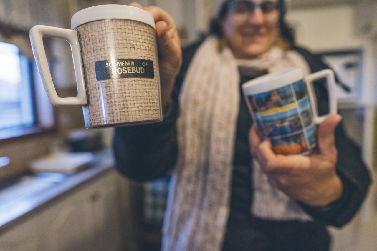 Person holding up a Souvenir of Rosebud mug during a deceased estate documentary photography session, Melbourne