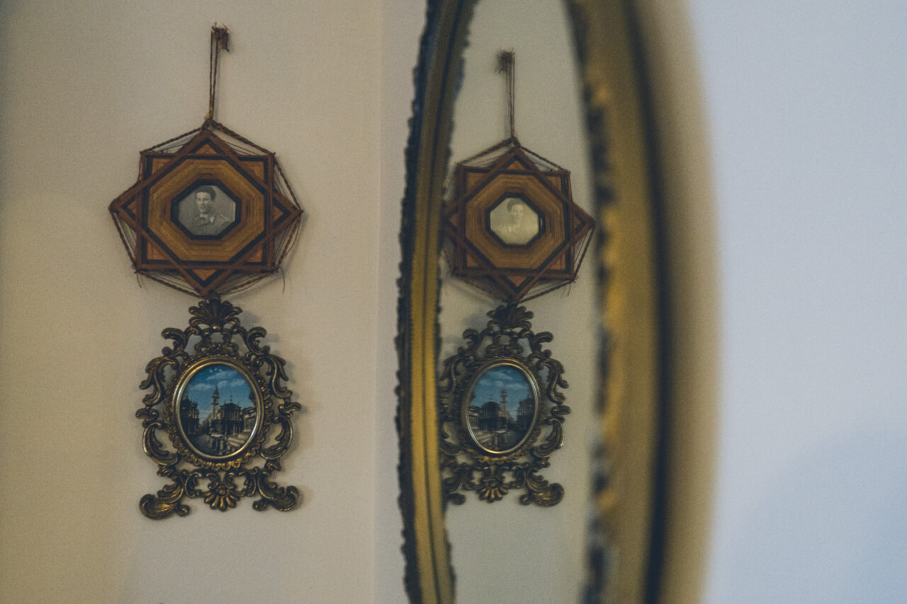 Antique hanging portrait frames reflected in a gold mirror, detail from a deceased estate documentary photography session in Melbourne