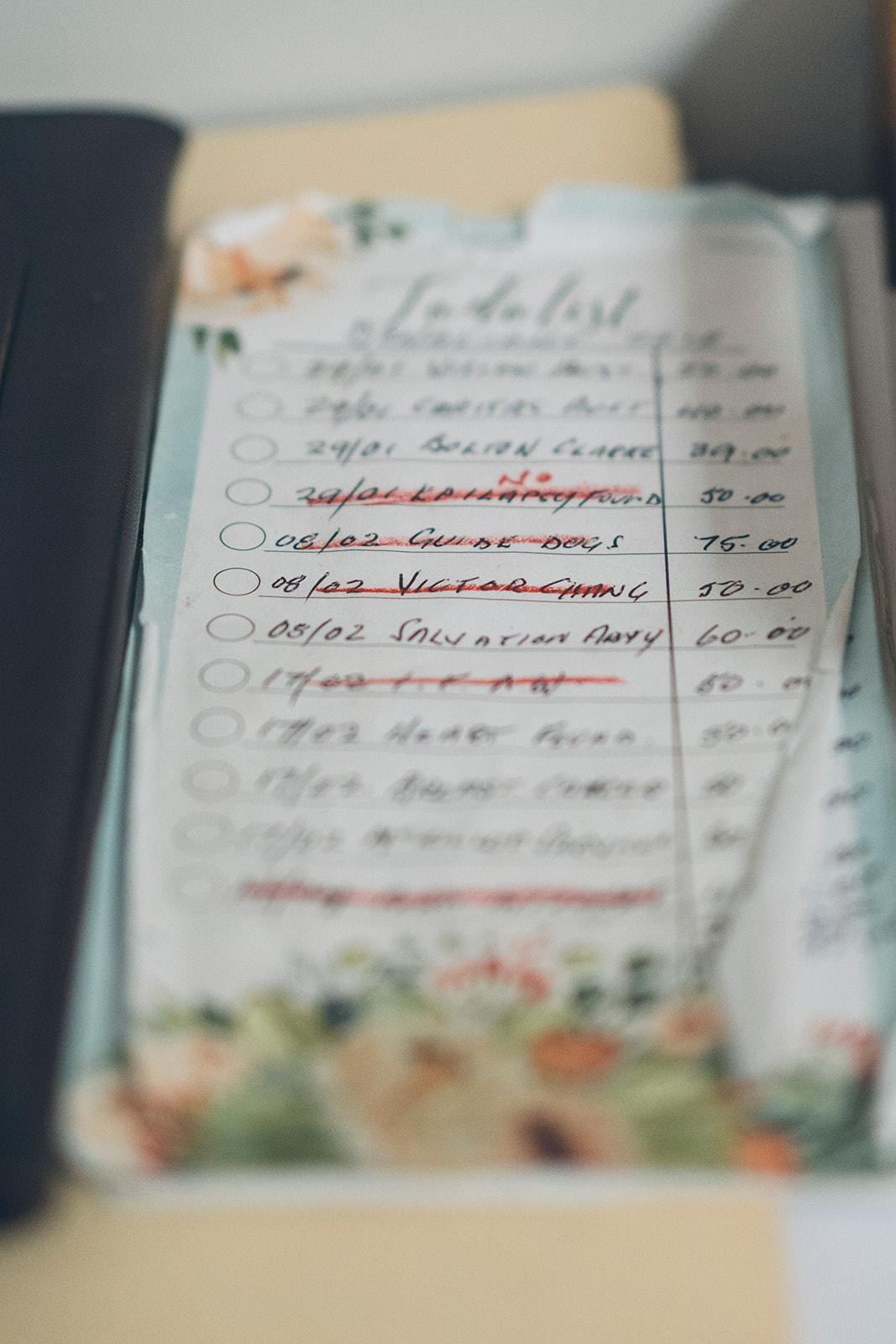 Handwritten to do list showing regular donations to charities including Guide Dogs and Salvation Army, detail from a documentary family home session