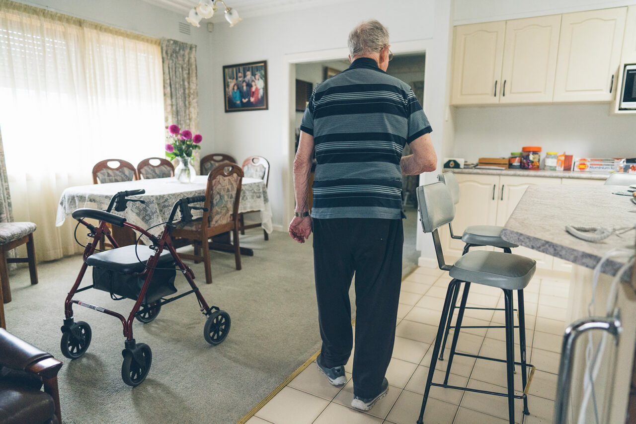 Elderly man walking away through the kitchen of his family home, documentary family home photography Melbourne