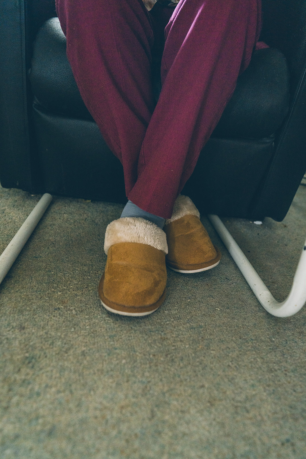 Close up of an elderly person's feet wearing sheepskin slippers, detail from a documentary family home photography session