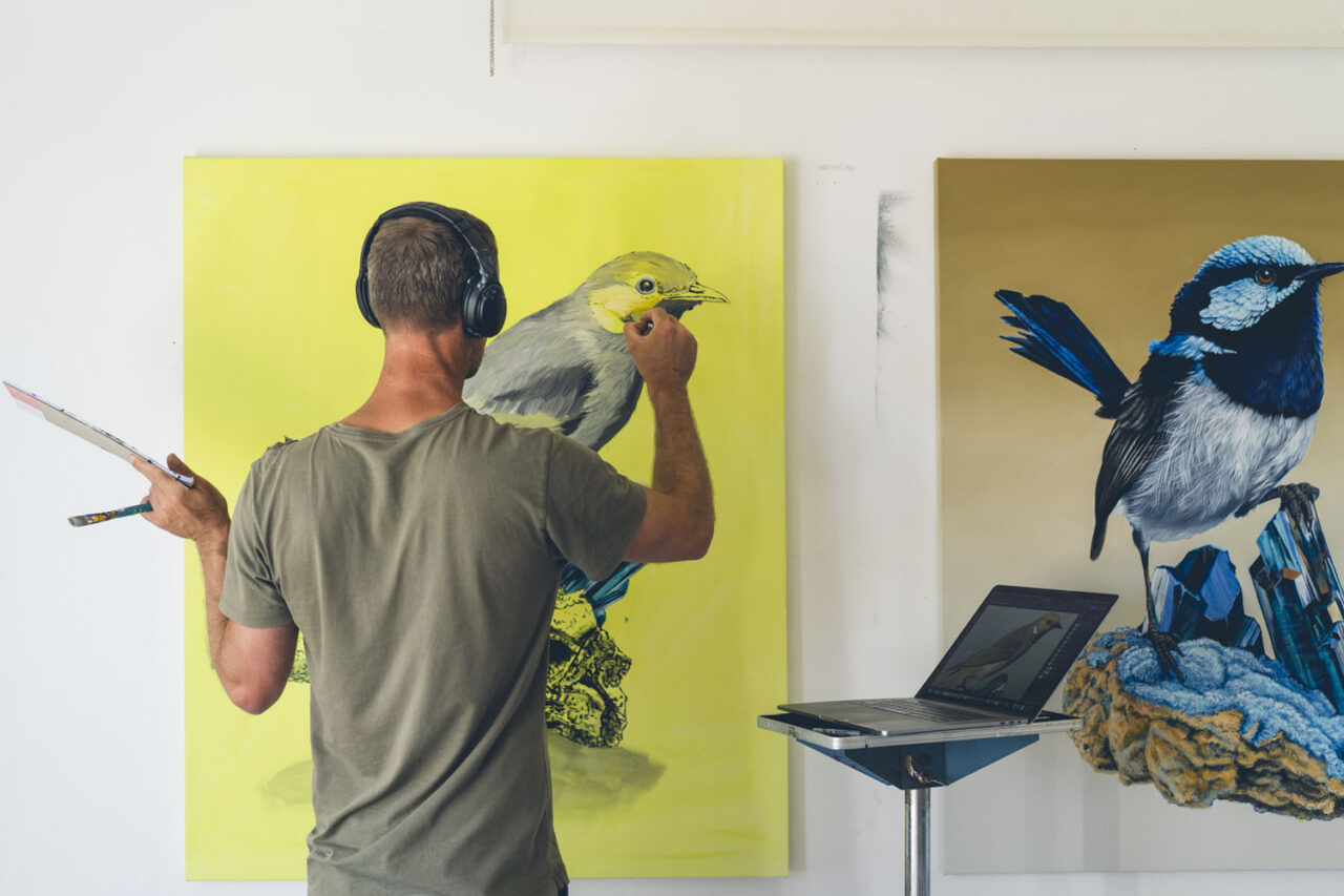 Documentary portrait of an artist painting large scale bird artwork on canvas in their studio wearing headphones, personal branding photography by LJM Photography Surf Coast