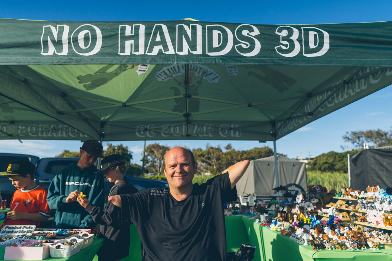 Man smiling in front of No Hands 3D market stall at Nightjar Markets on the Surf Coast, documentary community photography by LJM Photography