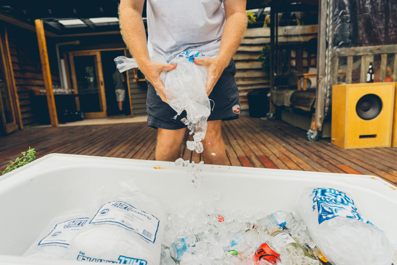 Person pouring ice into a bathtub being used as a drinks esky at a backyard wedding on the Surf Coast Caption: The bathtub esky. Still being loaded right up until go time.
