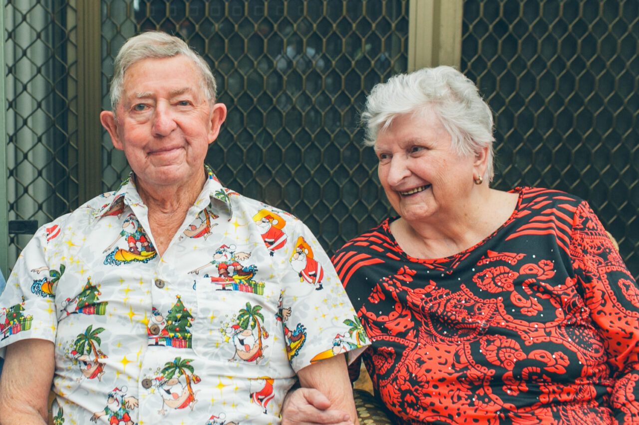 Elderly couple sitting together and smiling during a documentary family home photography session, Melbourne