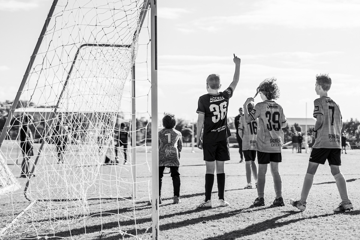unior soccer players calling for the corner kick in, black and white