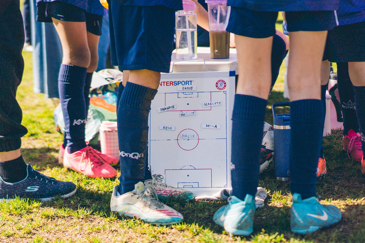 Girls soccer team gathered around a tactics board before a match