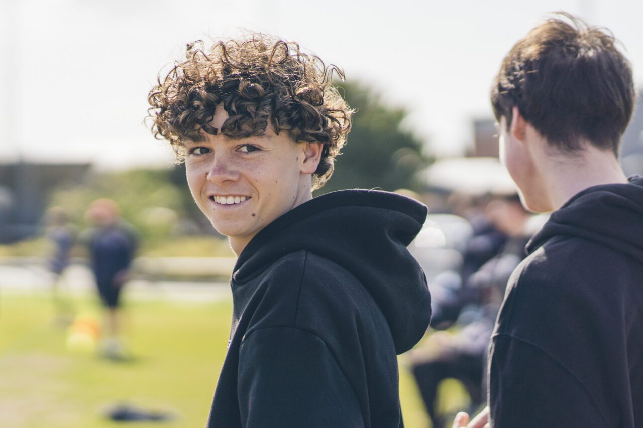 Teenage soccer player smiling back over his shoulder