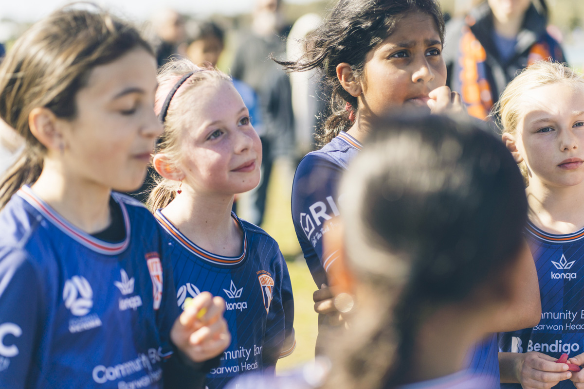 Close up of girls soccer teammates standing together, candid expressions