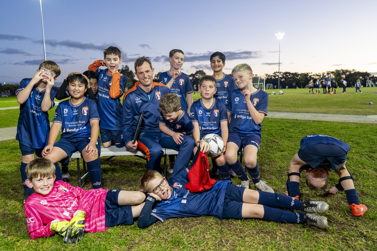 Under 10 soccer team group photo with coach at dusk on the Surf Coast